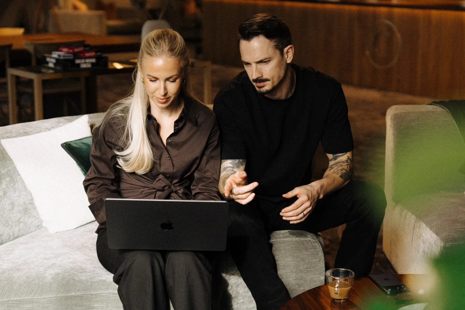 Två från Maraton går igenom en kunds siffror på en laptop